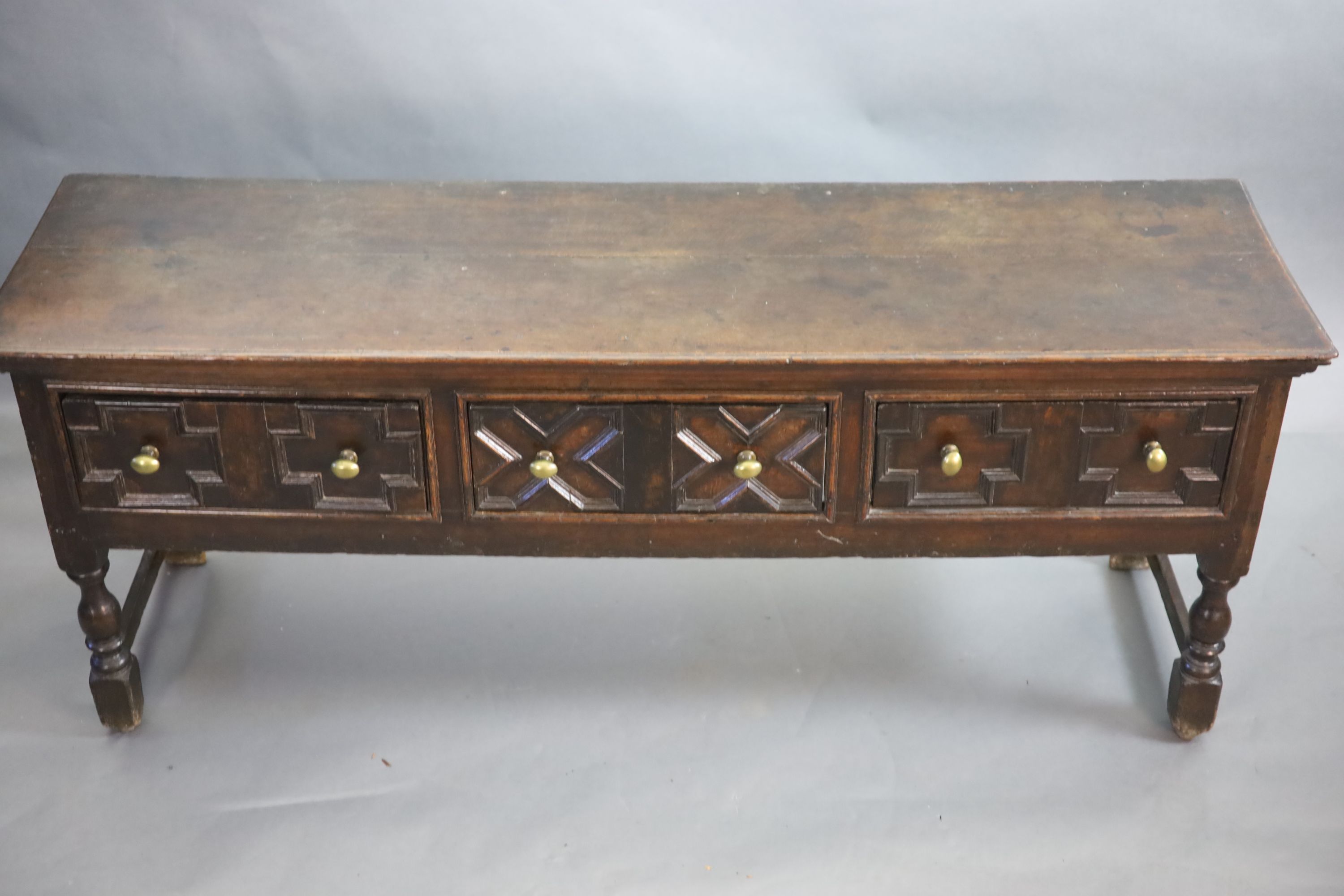 A late 17th century oak dresser fitted three short drawers raised on turned legs